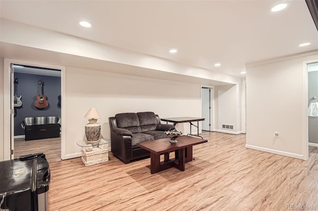 living area with baseboards, wood finished floors, visible vents, and recessed lighting