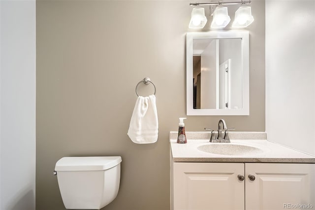half bathroom featuring toilet and vanity