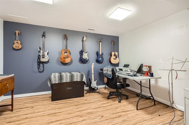 office space featuring baseboards, wood finished floors, and visible vents