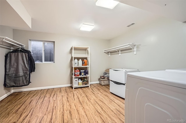 laundry room featuring laundry area, light wood-style flooring, baseboards, visible vents, and independent washer and dryer