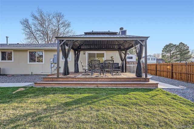 back of property featuring a gazebo, a yard, fence, and a deck