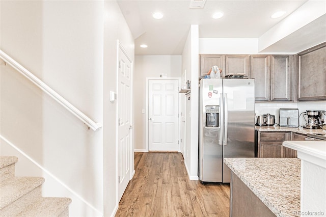 kitchen featuring stainless steel refrigerator with ice dispenser and light hardwood / wood-style floors