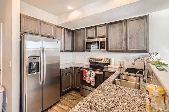 kitchen featuring light stone countertops, appliances with stainless steel finishes, and sink