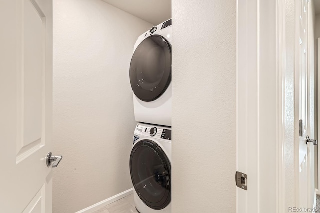 washroom featuring light tile patterned flooring and stacked washer and dryer