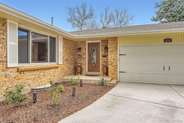 6238 S Cherry Cir, Centennial, CO 80121 - property entrance with a garage, concrete driveway, roof with shingles, and brick siding