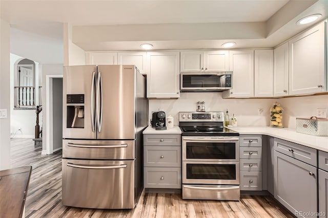 6238 S Cherry Cir, Centennial, CO 80121 - kitchen with light countertops, appliances with stainless steel finishes, gray cabinets, and light wood-type flooring