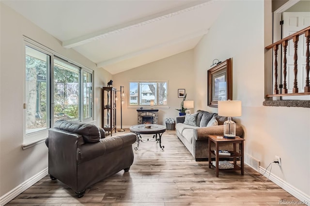 6238 S Cherry Cir, Centennial, CO 80121 - living area featuring visible vents, a fireplace, baseboards, light wood finished floors, and vaulted ceiling with beams