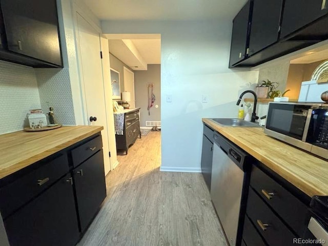 12546 E Cornell Ave Unit 104, Aurora, CO 80014 - kitchen with wood counters, stainless steel appliances, light wood-style floors, and dark cabinets