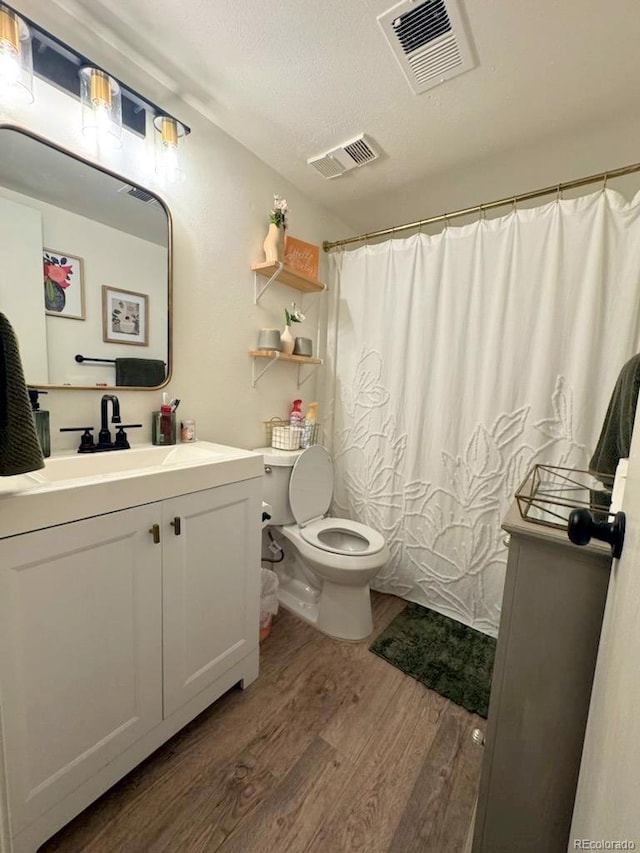 12546 E Cornell Ave Unit 104, Aurora, CO 80014 - full bath featuring wood finished floors, vanity, a shower with shower curtain, and a textured ceiling