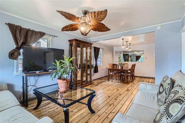 living room with a wealth of natural light, light hardwood / wood-style floors, and ceiling fan