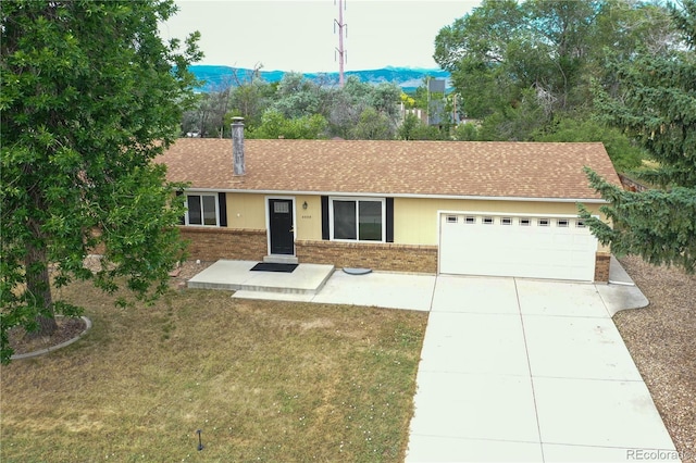 4559 Ashfield Dr, Boulder, CO 80301 - ranch-style home with brick siding, an attached garage, driveway, and a front yard