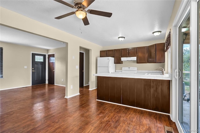 4559 Ashfield Dr, Boulder, CO 80301 - kitchen with under cabinet range hood, white appliances, dark wood-type flooring, dark brown cabinets, and a peninsula