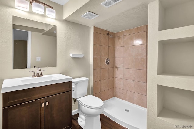 4559 Ashfield Dr, Boulder, CO 80301 - full bathroom with tiled shower, vanity, a textured wall, and wood finished floors