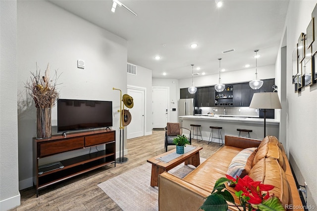 living room with light wood-style flooring, recessed lighting, and baseboards