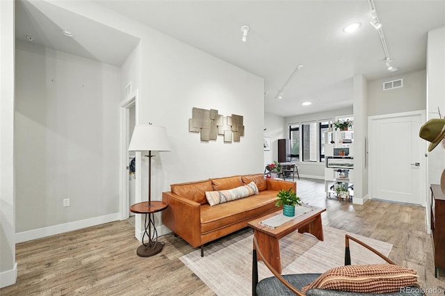 living area with light wood-type flooring, track lighting, baseboards, and recessed lighting