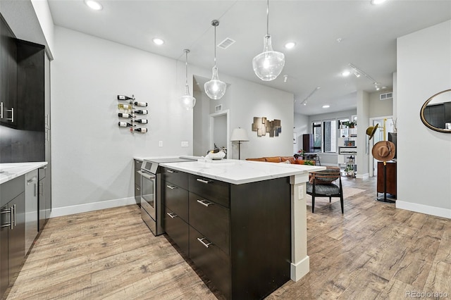 kitchen featuring a peninsula, stainless steel electric stove, light wood-style flooring, light stone counters, and hanging light fixtures