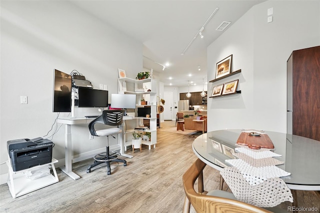 office area with wood finished floors, track lighting, and baseboards