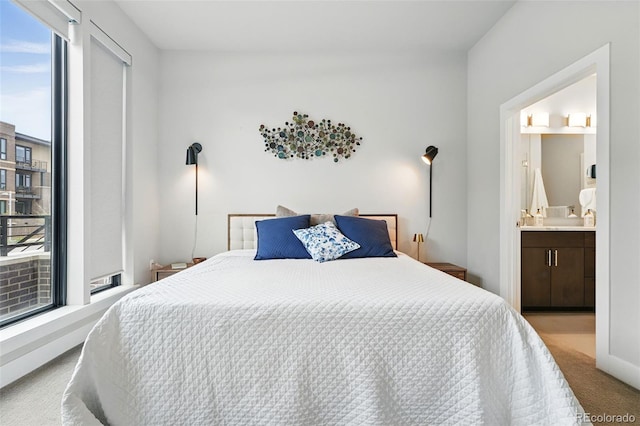 bedroom with carpet, baseboards, and ensuite bathroom