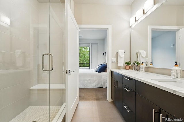 ensuite bathroom featuring a shower stall, tile patterned floors, and double vanity
