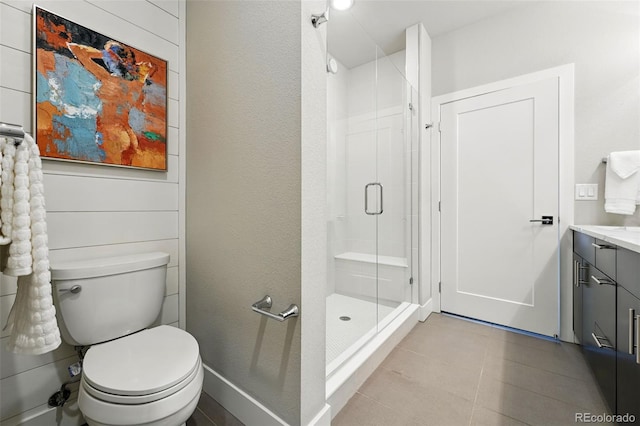 full bathroom with a shower stall, vanity, tile patterned flooring, and toilet