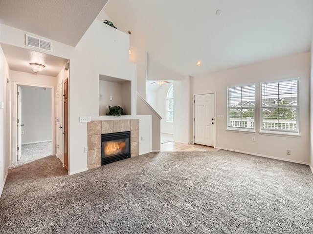 16366 E Fremont Ave Unit 11, Aurora, CO 80016 - unfurnished living room with carpet flooring, vaulted ceiling, a tile fireplace, and ceiling fan