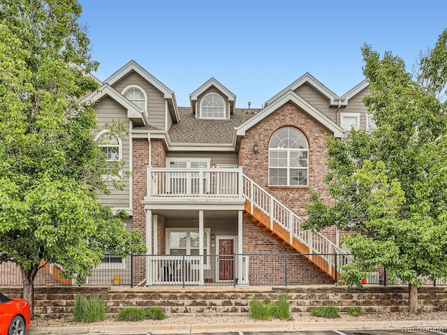 16366 E Fremont Ave Unit 11, Aurora, CO 80016 - view of front of home featuring brick siding, a shingled roof, stairway, and a balcony