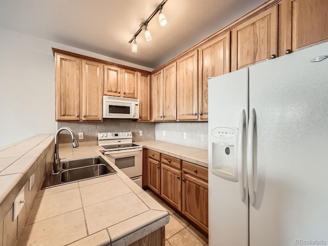 16366 E Fremont Ave Unit 11, Aurora, CO 80016 - kitchen featuring white appliances, a sink, tile countertops, backsplash, and light tile patterned floors