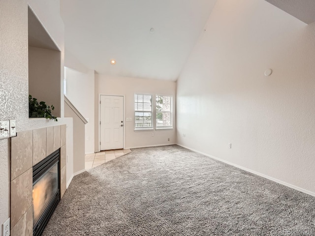 16366 E Fremont Ave Unit 11, Aurora, CO 80016 - unfurnished living room with light colored carpet, a tile fireplace, lofted ceiling, and baseboards