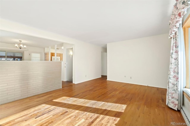 unfurnished room featuring hardwood / wood-style floors and a notable chandelier