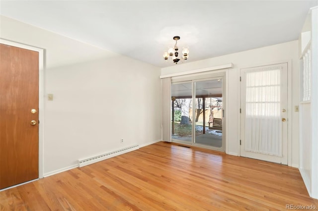 interior space with a notable chandelier, light wood-type flooring, and a baseboard heating unit