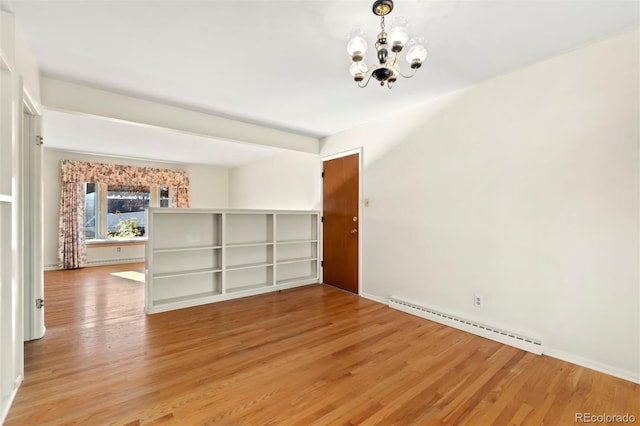 spare room with a baseboard radiator, a notable chandelier, and hardwood / wood-style flooring