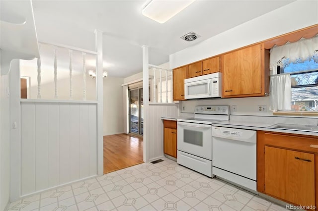 kitchen with white appliances, light hardwood / wood-style floors, and sink