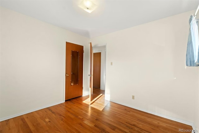 unfurnished room with hardwood / wood-style floors