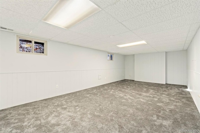 basement featuring carpet flooring and a drop ceiling