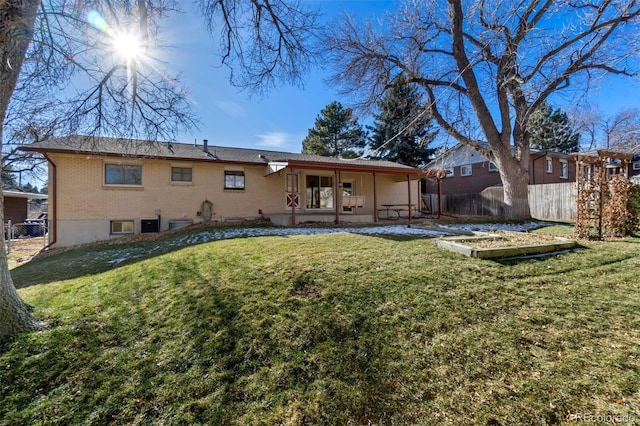 rear view of property featuring a lawn