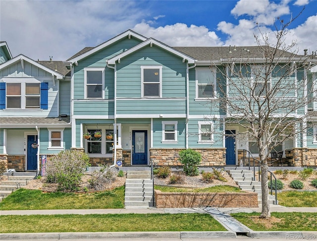 view of front of home with stone siding and a shingled roof