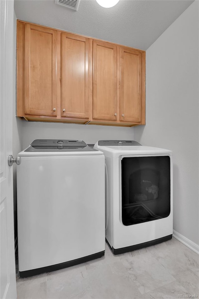 5762 Ceylon St, Denver, CO 80249 - laundry area with separate washer and dryer, baseboards, and cabinet space