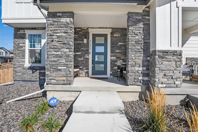 view of exterior entry featuring covered porch