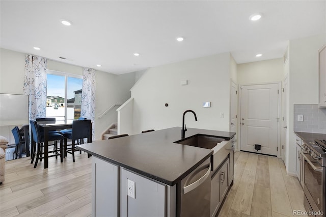 kitchen featuring light hardwood / wood-style floors, sink, a kitchen island with sink, and stainless steel appliances