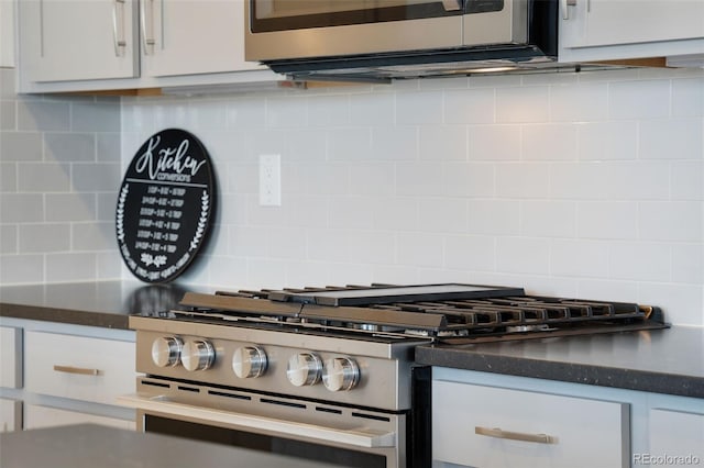 kitchen with stainless steel stove, decorative backsplash, and white cabinetry