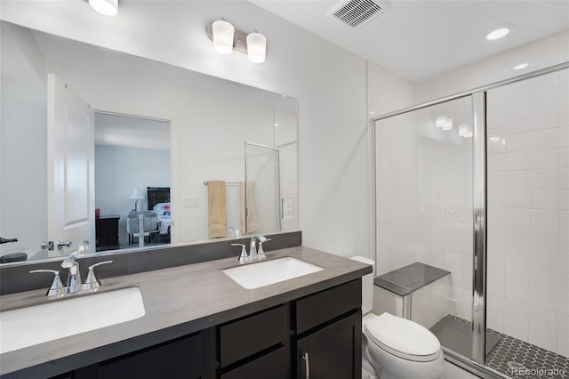 bathroom with a shower with shower door, vanity, and toilet