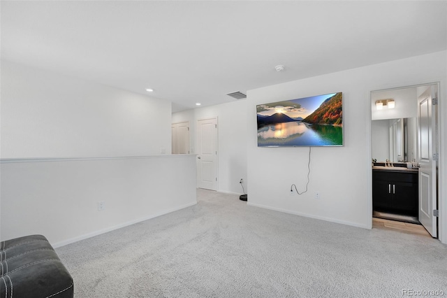 unfurnished living room with sink and light carpet