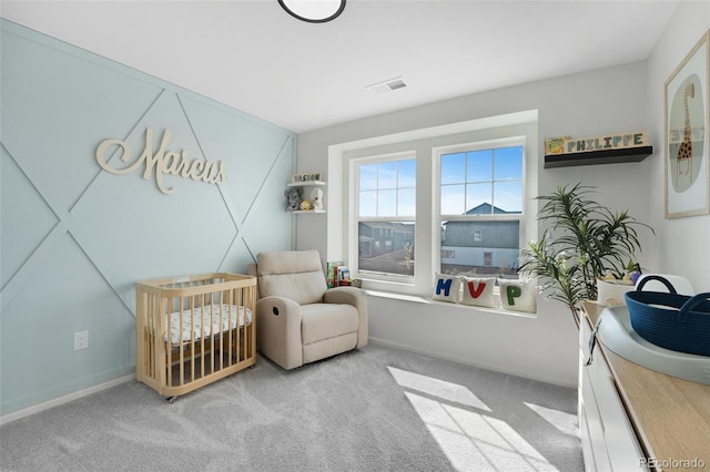 bedroom featuring a crib and light colored carpet