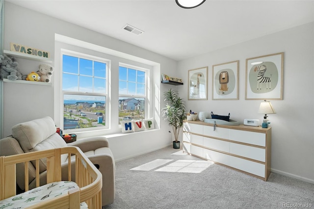 bedroom featuring a crib and light colored carpet