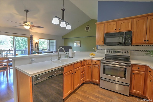 539 River View Dr Unit 1305, New Castle, CO 81647 - kitchen featuring black appliances, a peninsula, vaulted ceiling, decorative backsplash, and light wood-style flooring