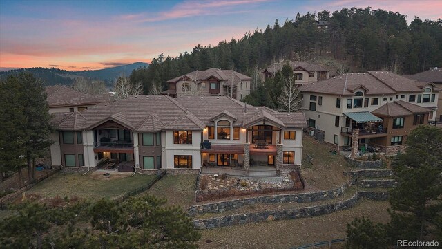 1015 Nob Hill Rd, Evergreen, CO 80439 - back of house with stucco siding, a mountain view, a patio, and a balcony