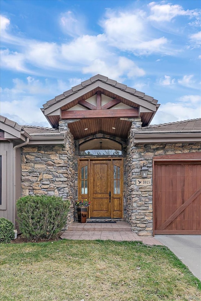 1015 Nob Hill Rd, Evergreen, CO 80439 - doorway to property with stone siding, a yard, and a garage
