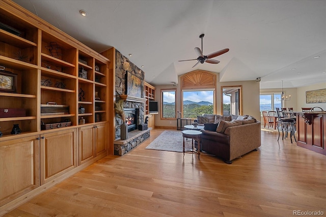1015 Nob Hill Rd, Evergreen, CO 80439 - living room featuring a fireplace, vaulted ceiling, light wood-style flooring, and ceiling fan