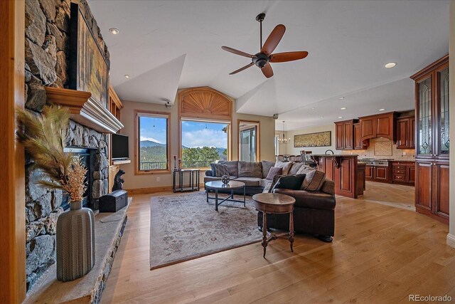 1015 Nob Hill Rd, Evergreen, CO 80439 - living area featuring light wood-style flooring, vaulted ceiling, recessed lighting, a ceiling fan, and a stone fireplace