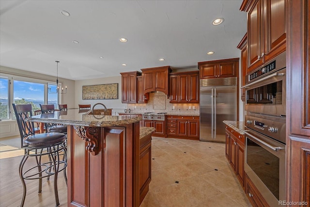 1015 Nob Hill Rd, Evergreen, CO 80439 - kitchen featuring built in fridge, a breakfast bar, custom exhaust hood, and dark stone countertops